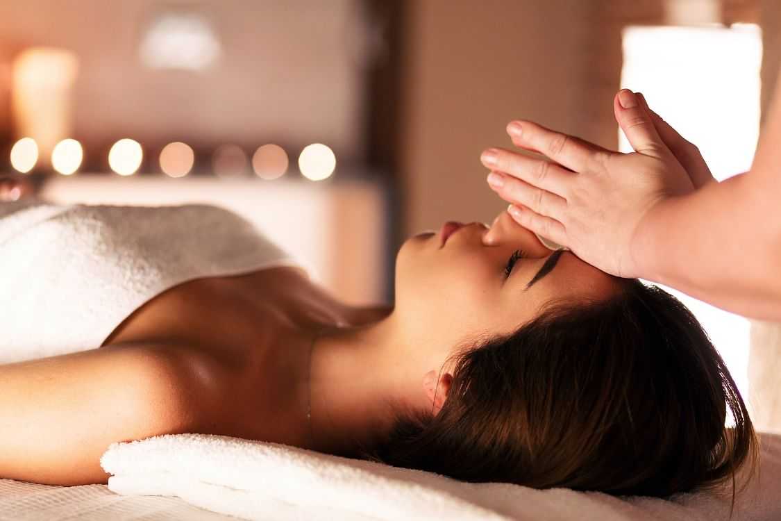 Woman receiving a relaxing forehead massage in a tranquil spa.